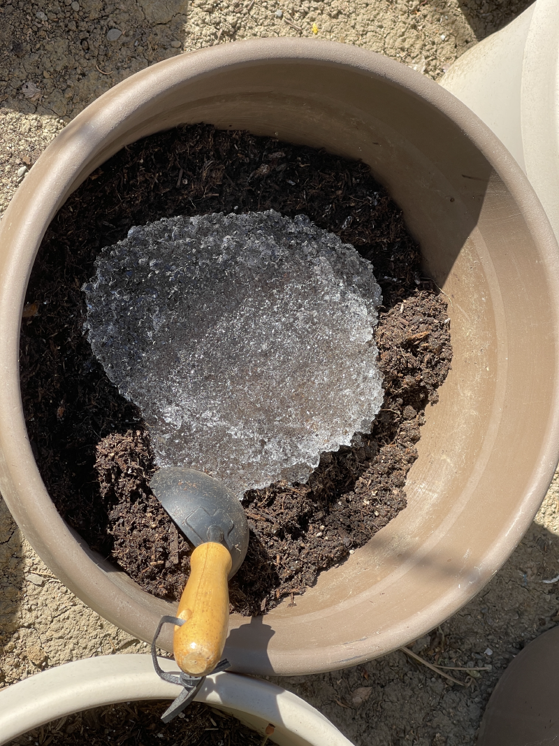 A closeup of the pot with the added soil and water gel.